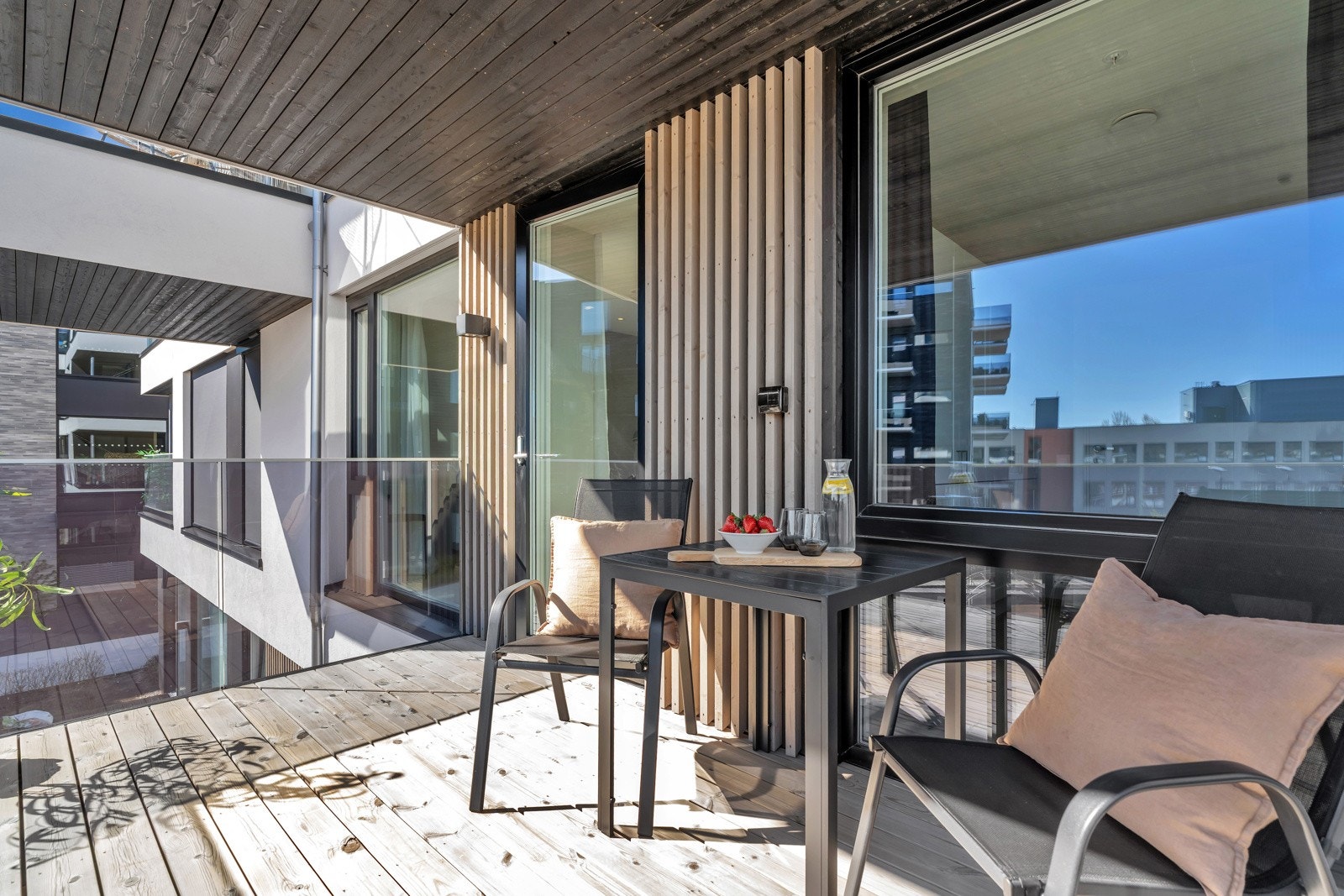 God plass til sittegruppe, grill og blomsterkrukker på veranda. Galleribilde