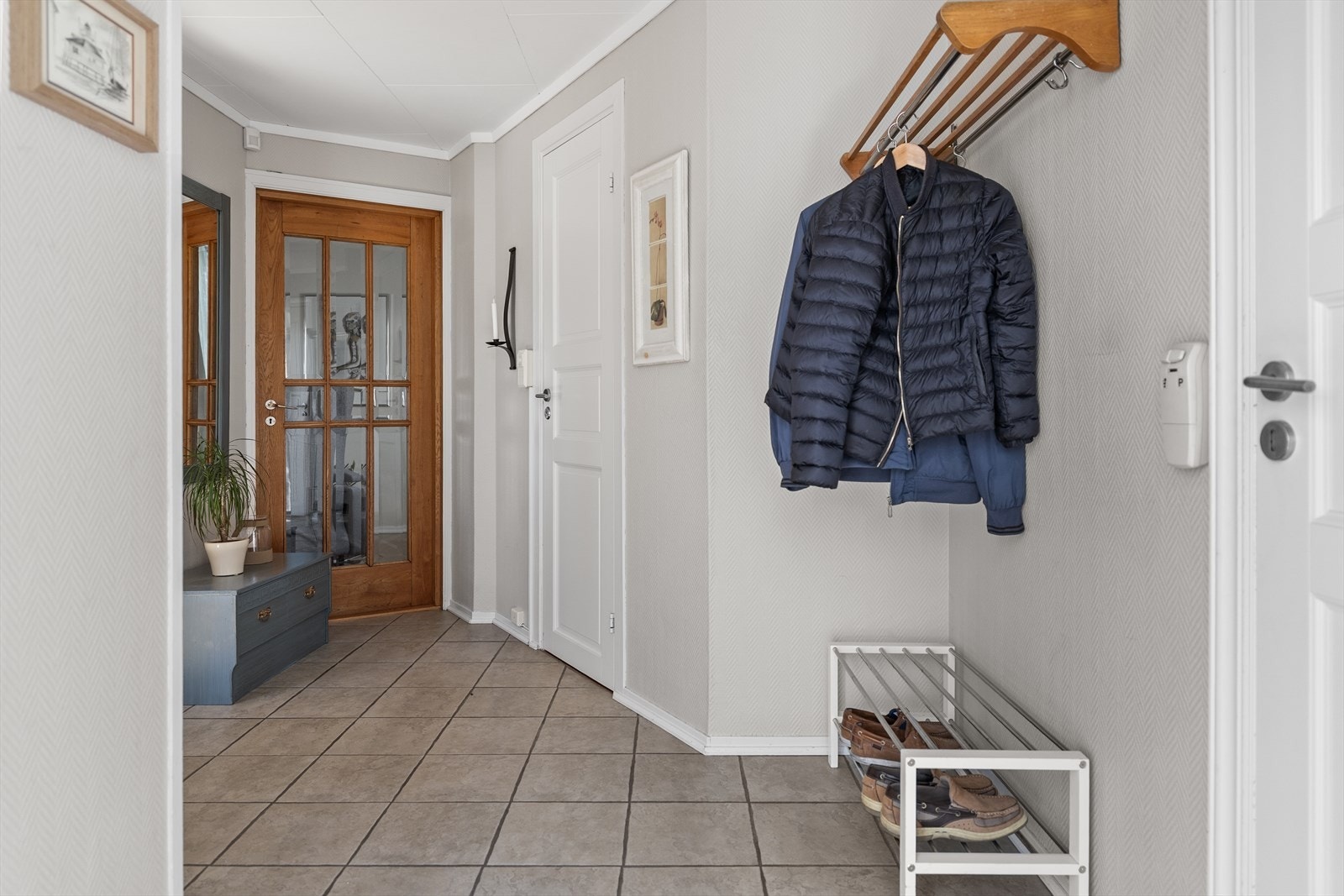 Velkommen inn i en lys og innbydende entré som gir et godt førsteinntrykk av boligen. Her er det god plass til oppbevaring av yttertøy og sko. Galleribilde