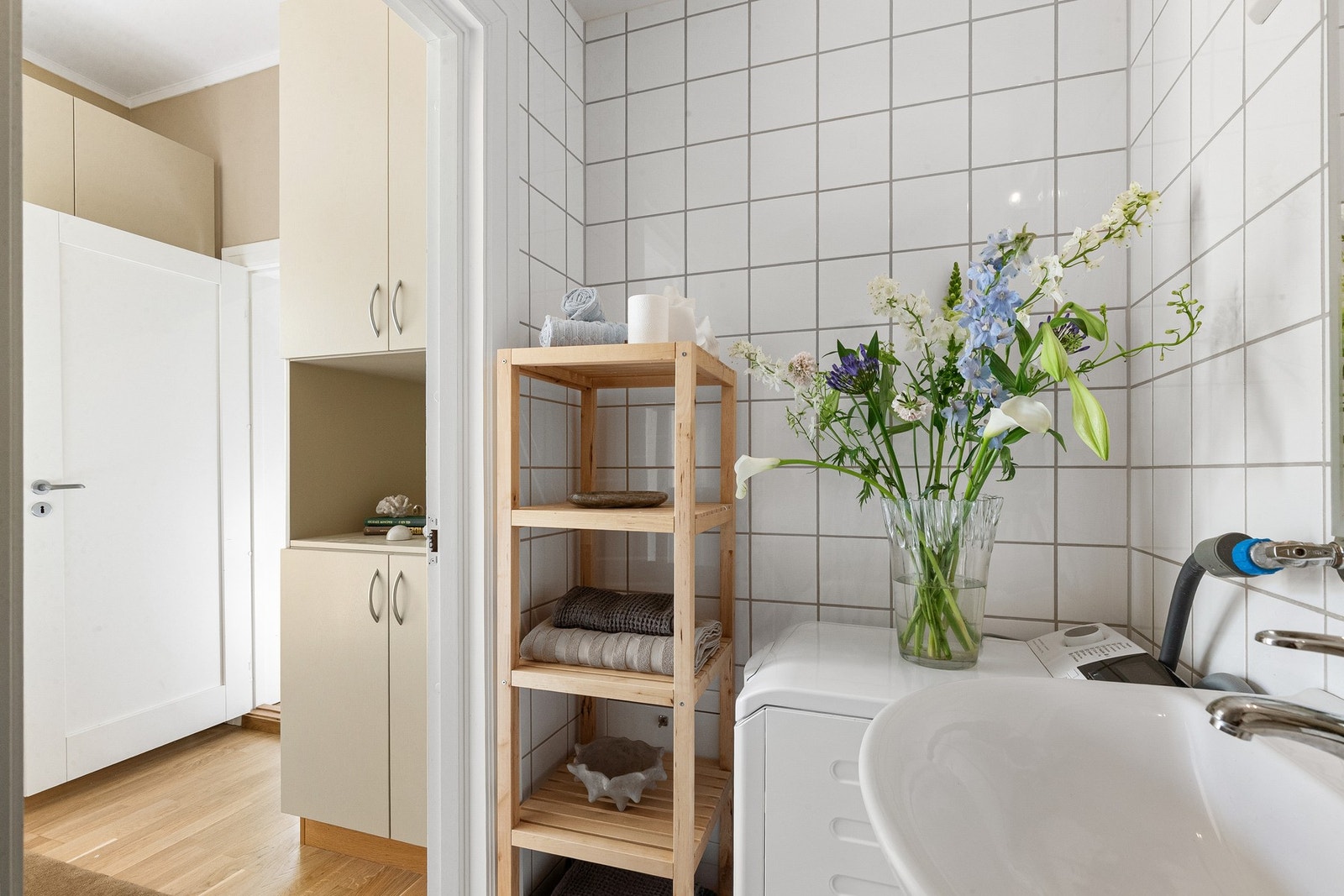 Badet er innredet med vegghengt toalett, dusjsone med skyvedør, samt servant med underskap, speil og belysning over. Galleribilde