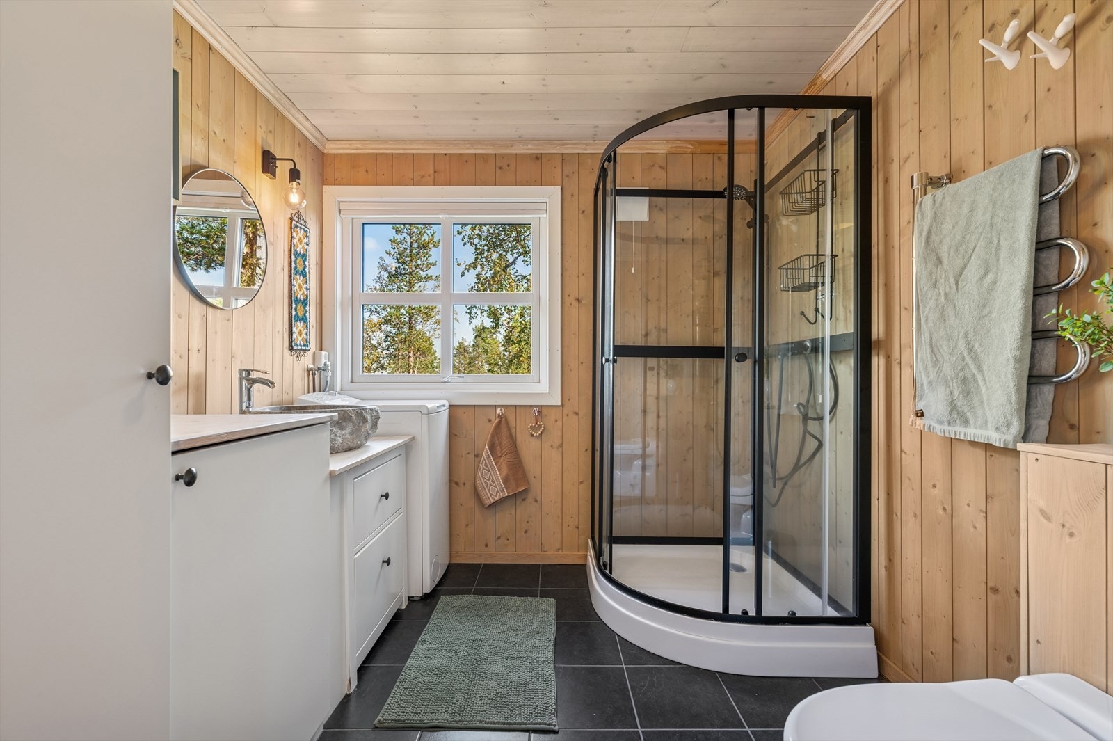 Badet fremstår lyst og pent, og er innredet med toalett, dusjkabinett samt servant med underskap og speil. Her får du et funksjonelt og trivelig rom med en moderne og praktisk utforming. Galleribilde