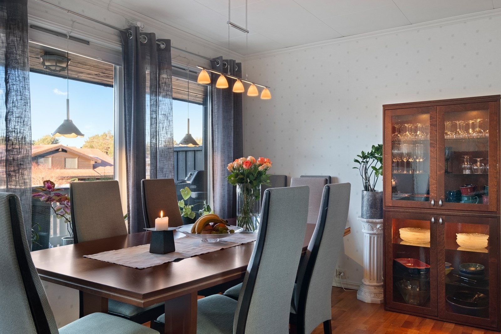 Spisestue med glasskap og store vinduer som gir utsikt. Galleribilde