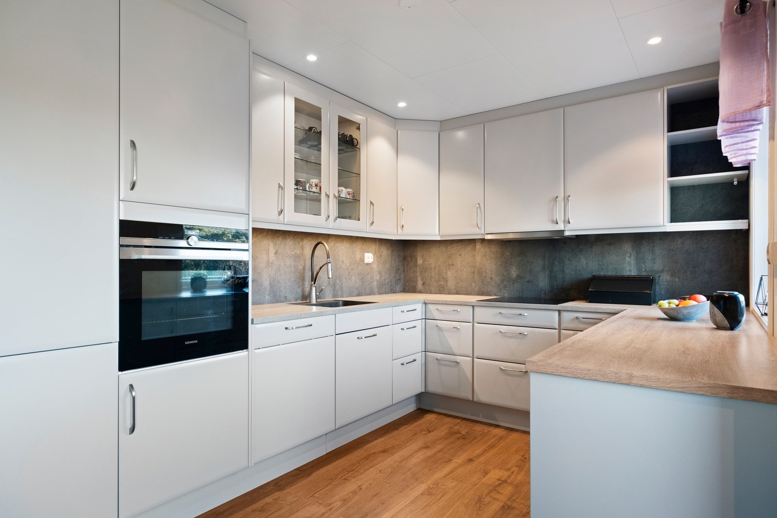 Kjøkkenet har lyse fronter og integrerte hvitevarer som gir en effektiv arbeidsplass. Galleribilde