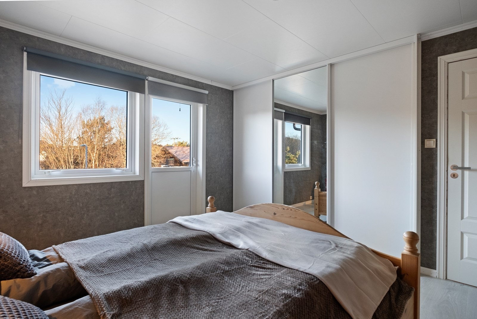 Skyvedørsgarderobe med speil gir rommet en praktisk oppbevaringsløsning. Galleribilde