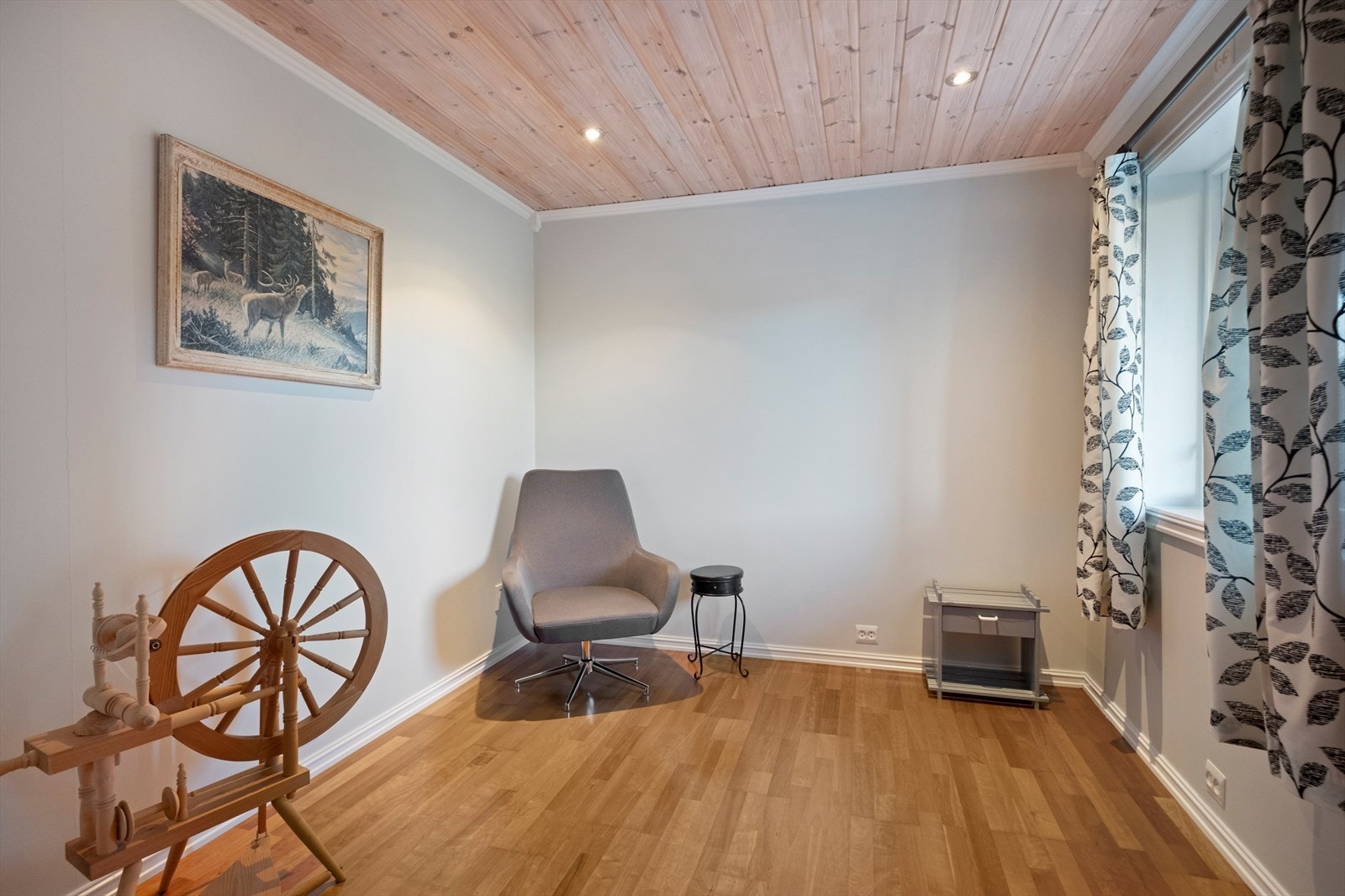 Lyst rom med tregulv og panel i taket gir et naturlig preg. Galleribilde