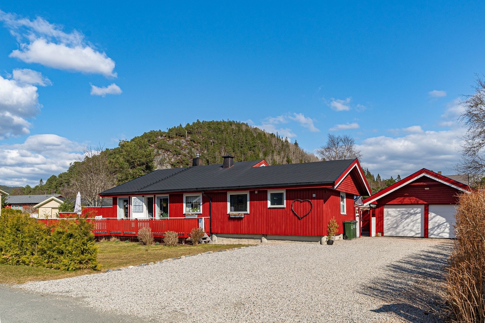 Pent opparbeidet tomt med stor gårdsplass, dobbeltgarasje med lagringsplass, flott hage og flere utesoner. Galleribilde