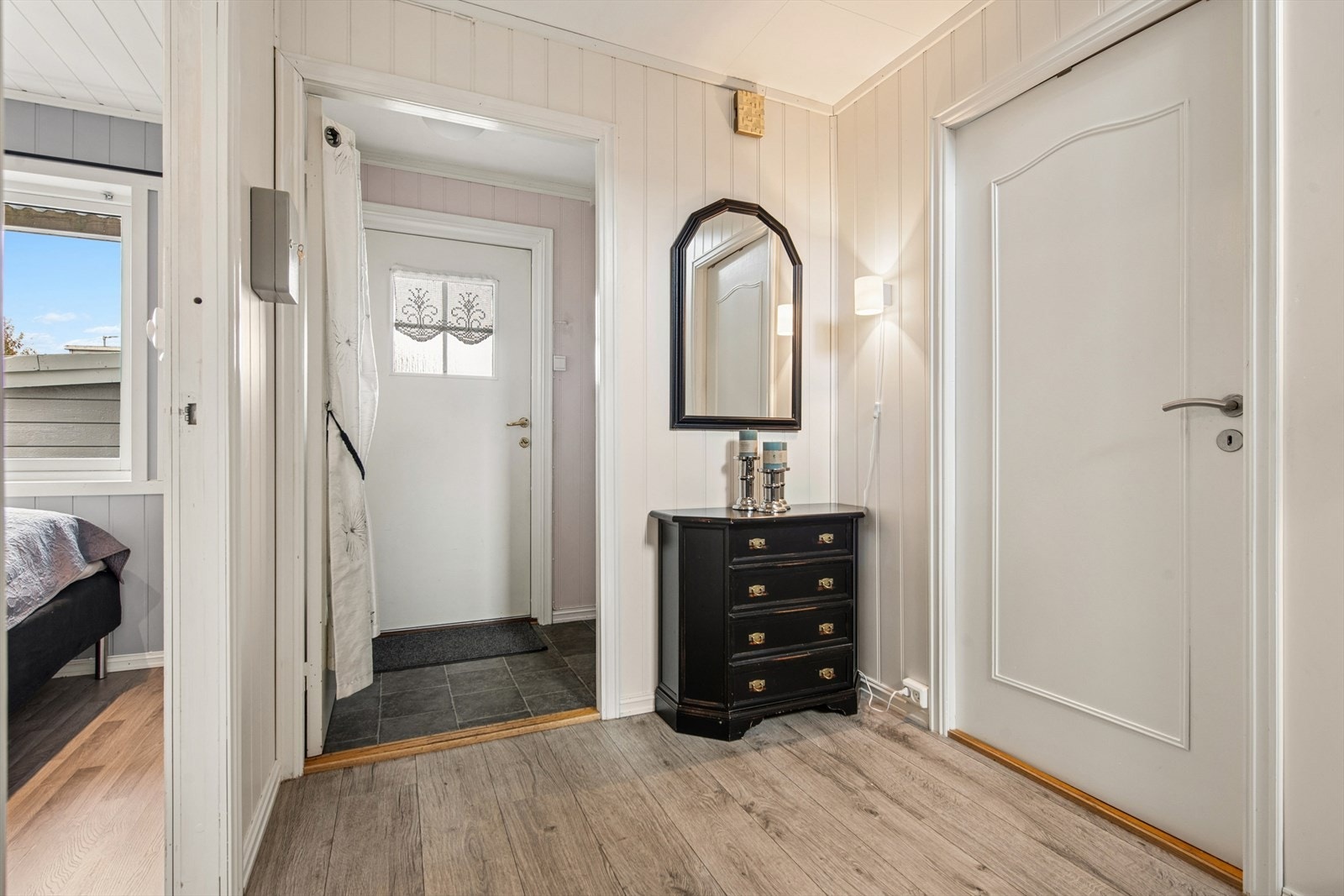Velkommen inn. Fra vindfanget kommer du inn i en hall som fordeler til etasjens rom og trappen opp til stuen. Galleribilde