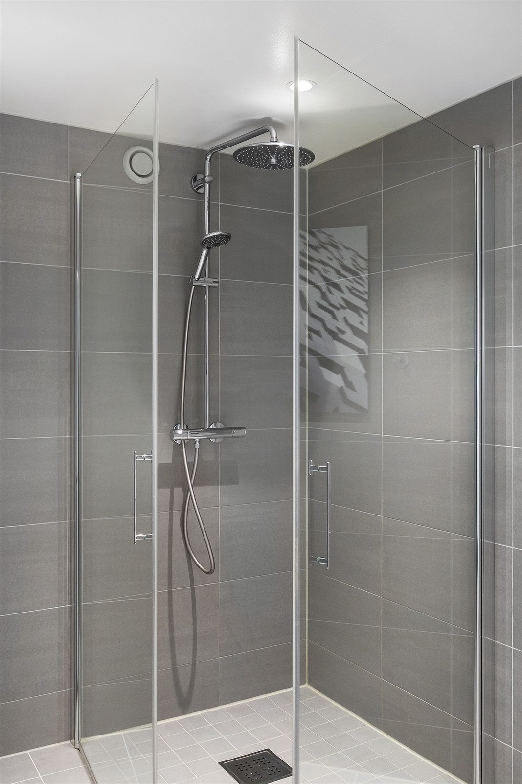 Dusjhjørne med glassdører samt både hånd- og regnfallsdusj fra Grohe. Galleribilde