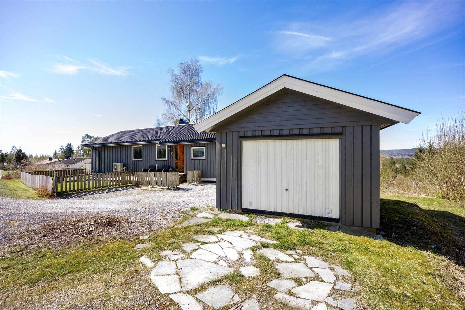 Eiendommen har en frittstående garasje med nyere sidedør, ny elbillader utvendig og et areal på ca. 26 kvm. Galleribilde