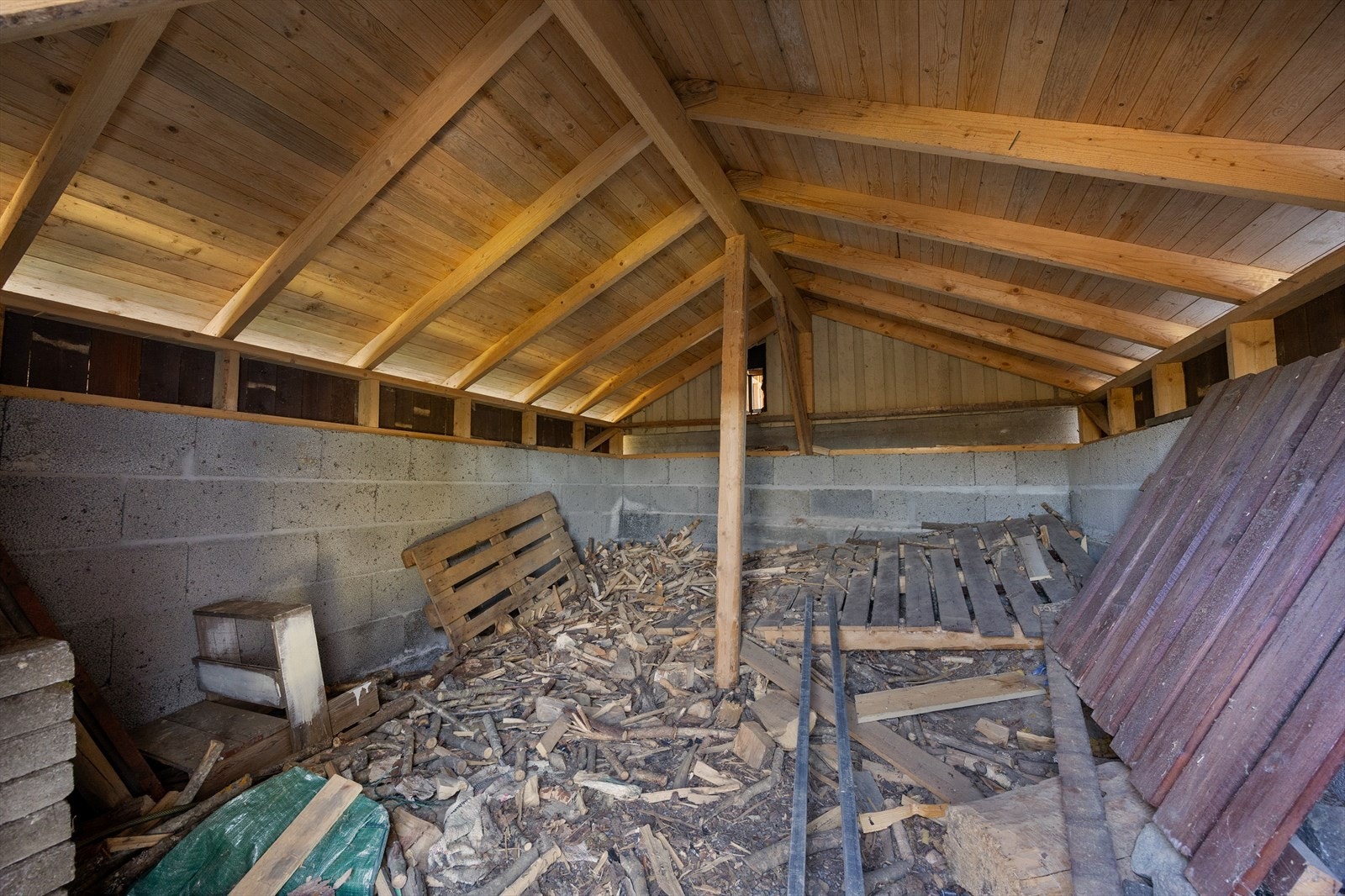 Garasjen har en tilbygd vedbod mot hagen. Bildet viser den tilbygde boden innvendig. Galleribilde