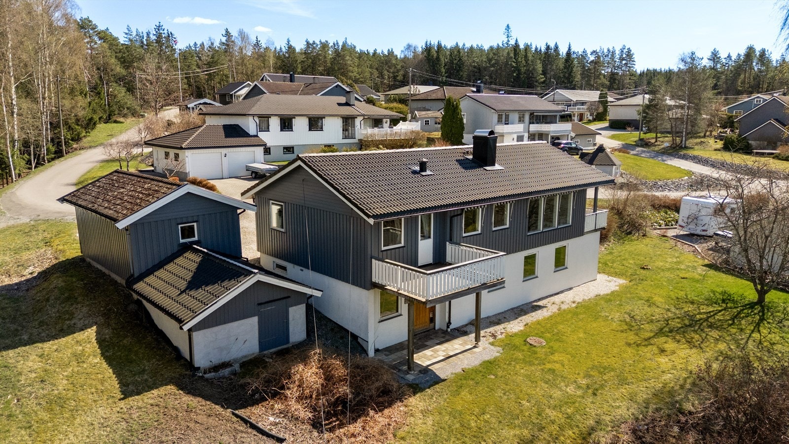 Tomten går over to nivåer, og på nedsiden har huset et stort hageareal med gressplen, prydbusker og diverse beplantning. Galleribilde