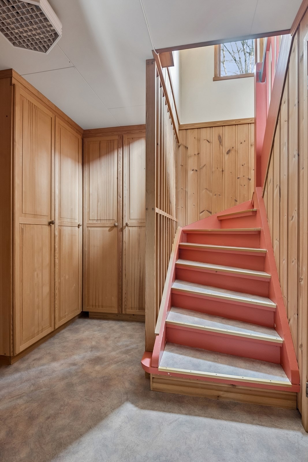 Tretrappen forbinder de to etasjene. I gangen i kjelleren er det god plass til oppbevaring i garderobeskap. Galleribilde