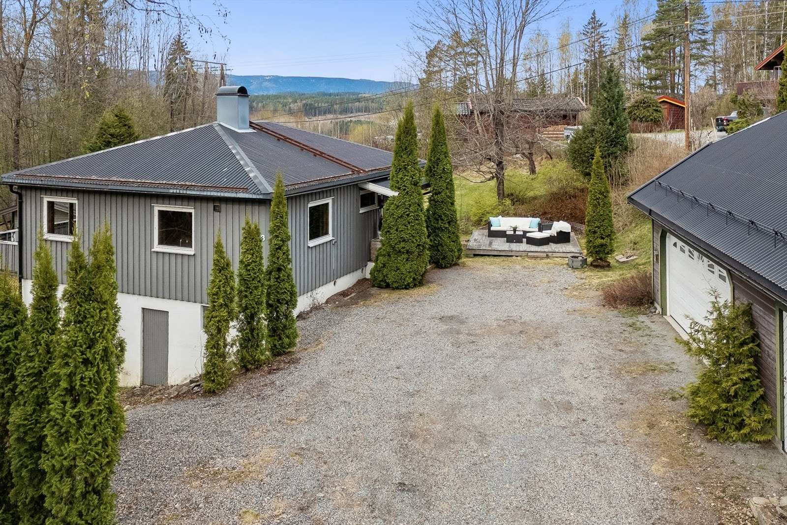 Eiendommen har et stort, gruset tun og et separat lagerbygg på 88 m² med garasje og gode lagringsmuligheter. Galleribilde