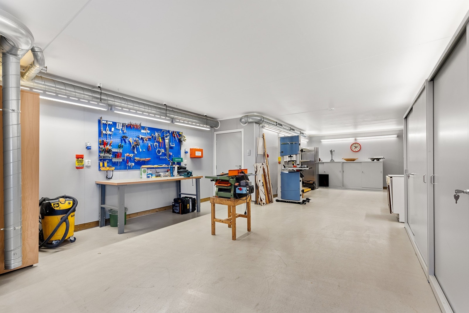 Det integrerte garasjeanlegget fremstår som et gjennomført og funksjonelt område med epoxymalt gulv, vannbåren gulvvarme, balansert ventilasjon, verkstedløsning og eget bad. Galleribilde