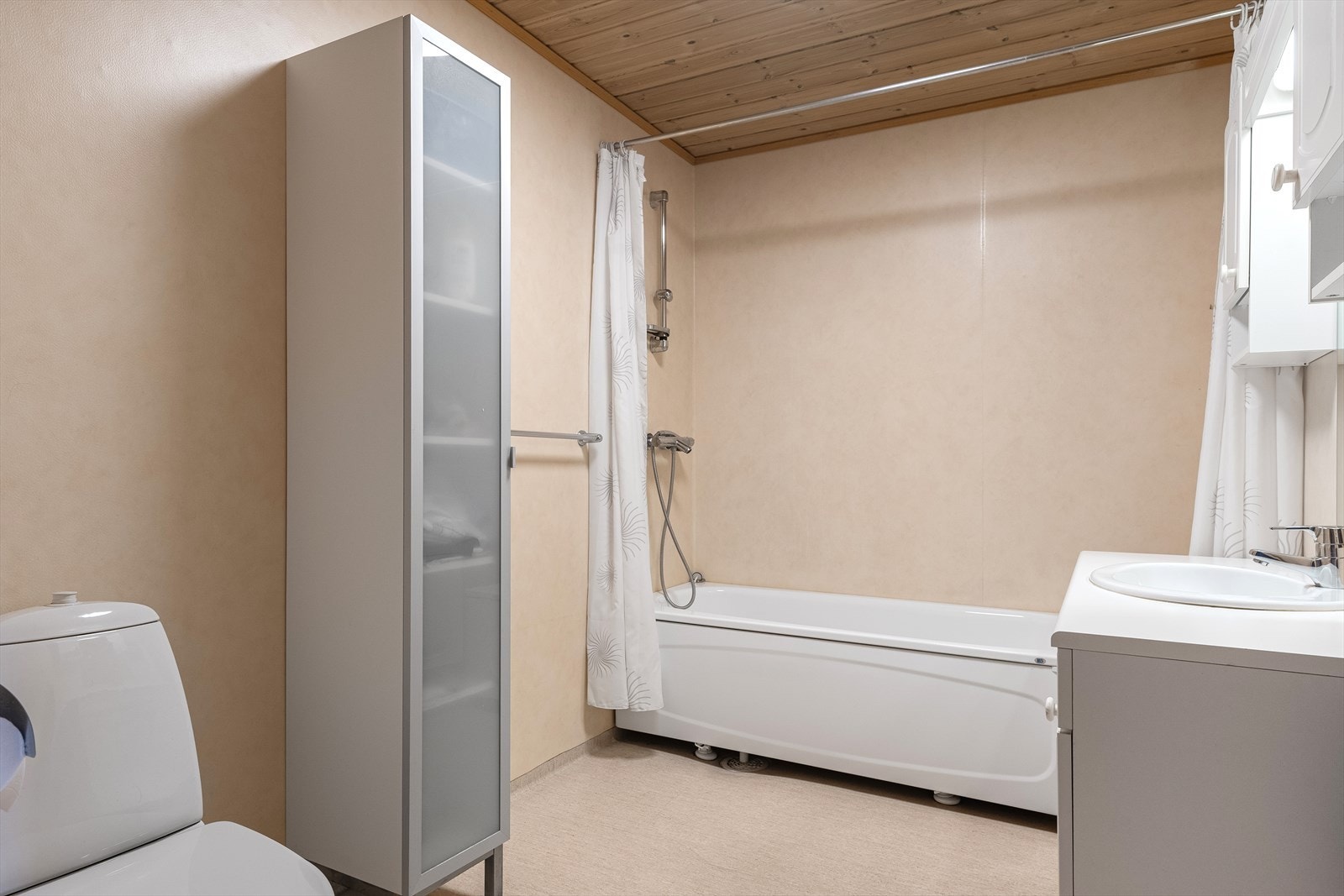 Badet er innredet med toalett, badekar, høyskap og servant i skapinnredning med under- og overskap. Galleribilde