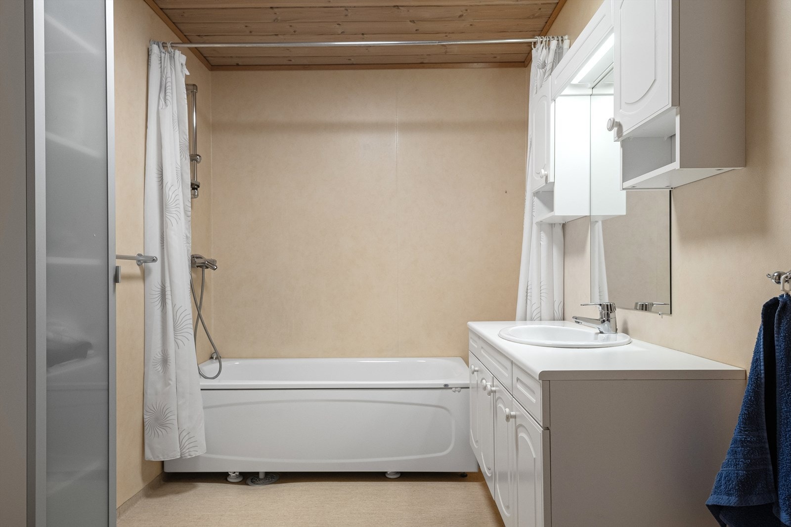 Badet har våtromstapet på vegg og venylbelegg på gulv. Varmekabler. Galleribilde
