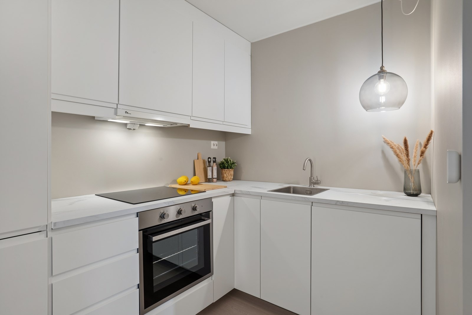 Lys og tidløs kjøkkeninnredning med folierte skrog med slette fronter samt laminert benkeplate. Galleribilde