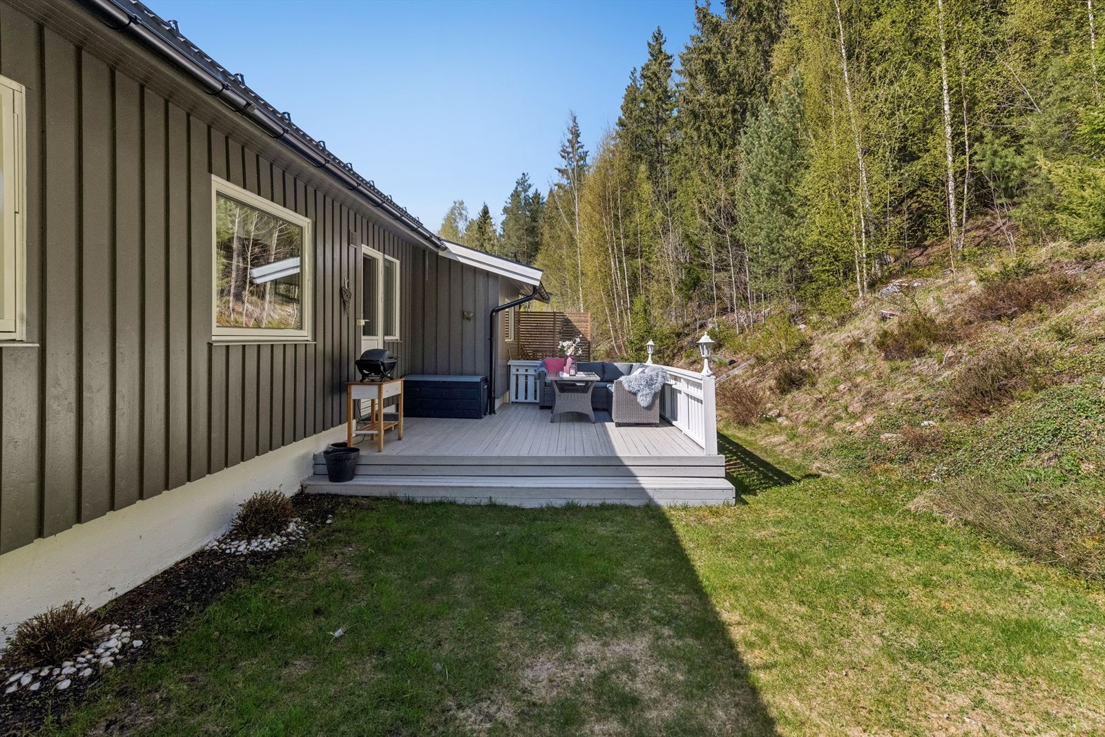 Den private hagen er pent opparbeidet med plen og ligger skjermet til, med skogen som nærmeste nabo. Galleribilde