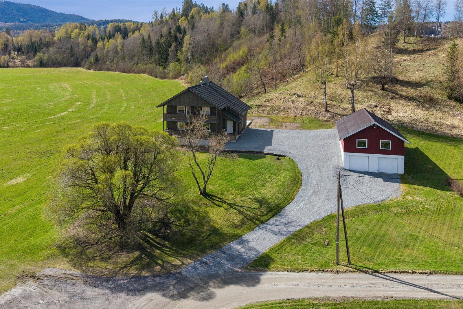 Flott beliggende landlig eiendom bestående av to bolighus, garasje og uthus. Galleribilde