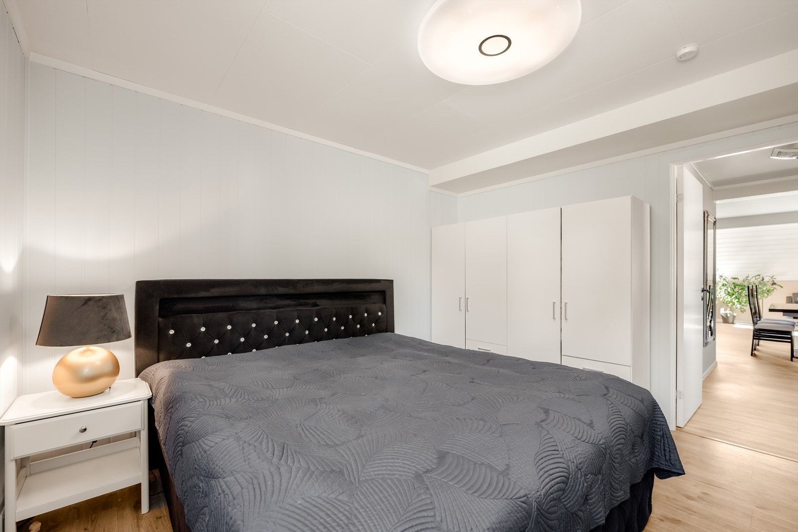 Rommet har malte panelplater på veggene og laminat på gulvet. Galleribilde