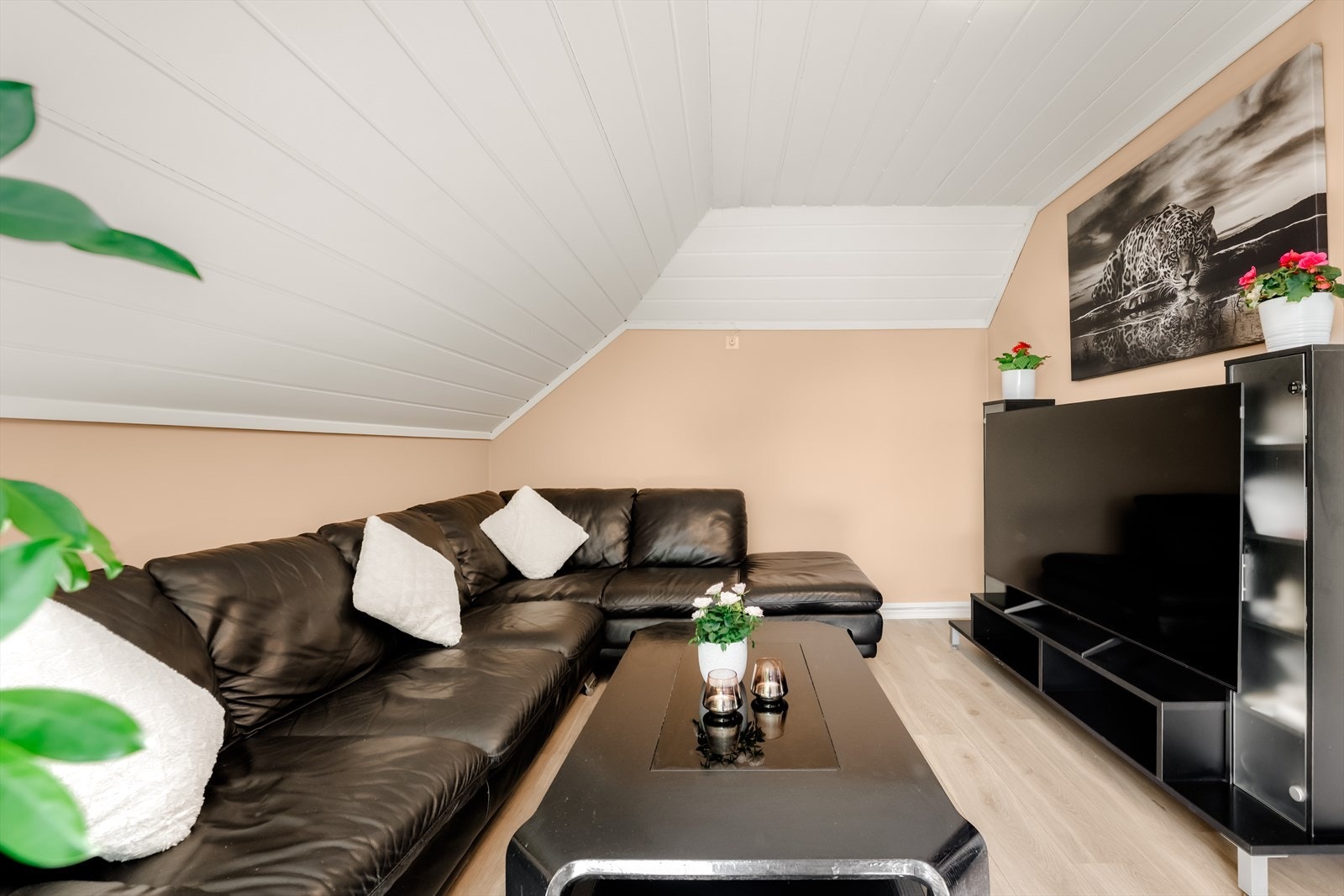 Stuen har en lun krok for sofagruppe under det skrå panelet i himlingen. Galleribilde