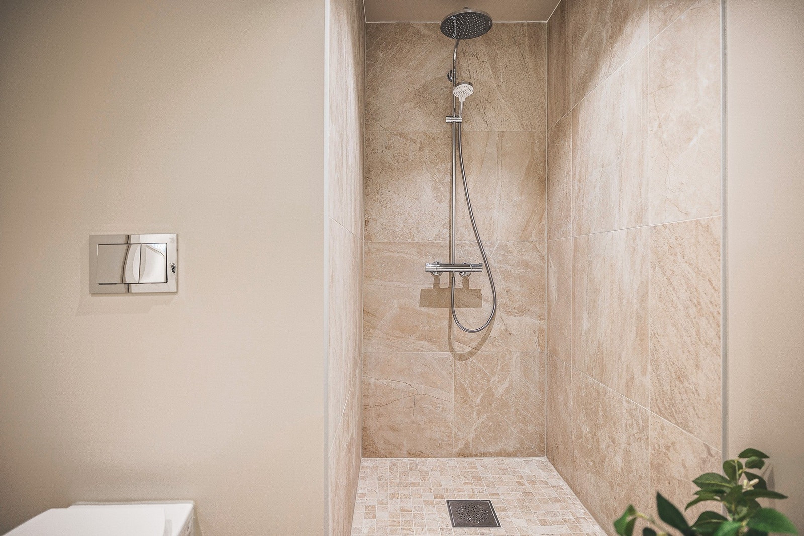 Badet er utstyrt med innfelte downlights, varmekabler i gulv, baderomsinnredning med nedfelt servant, vegghengt toalett og dusjhjørne. Galleribilde