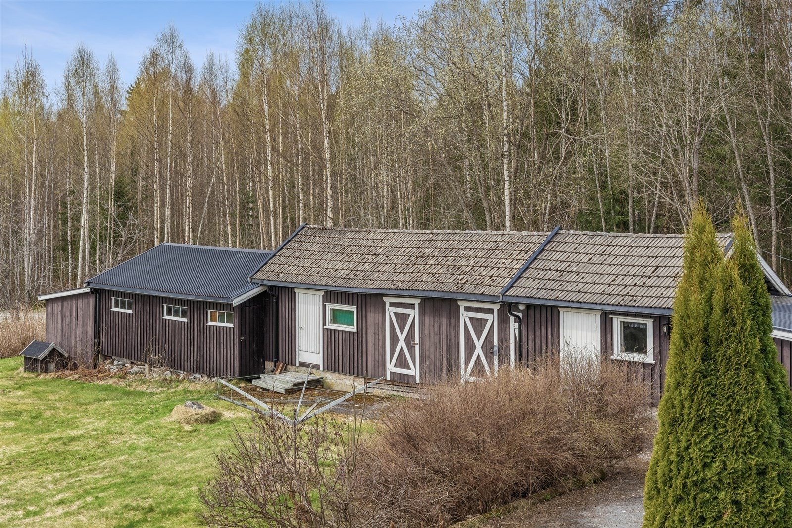 Garasje/uthus på 100 m2 med to garasjer, gang, lager, vedskåle, bod, snekkerbod og redskapsbod. Galleribilde