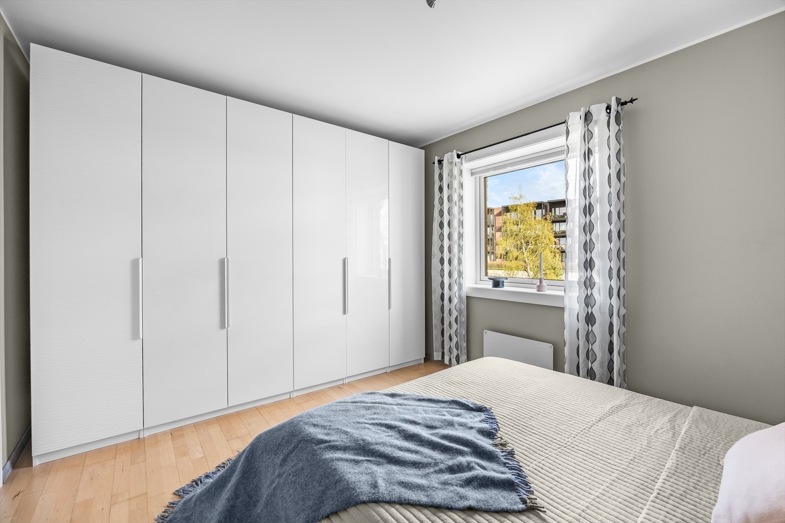 En hel vegg med garderobeskap gir rikelig med oppbevaringsplass. Galleribilde