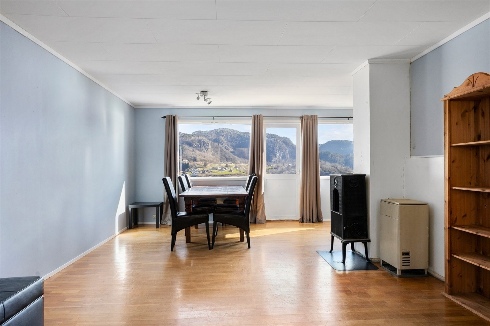 Stuen har plass til både spisebord og sofagruppe. Ett av vinduene i stuen ble skiftet i 2021. Galleribilde