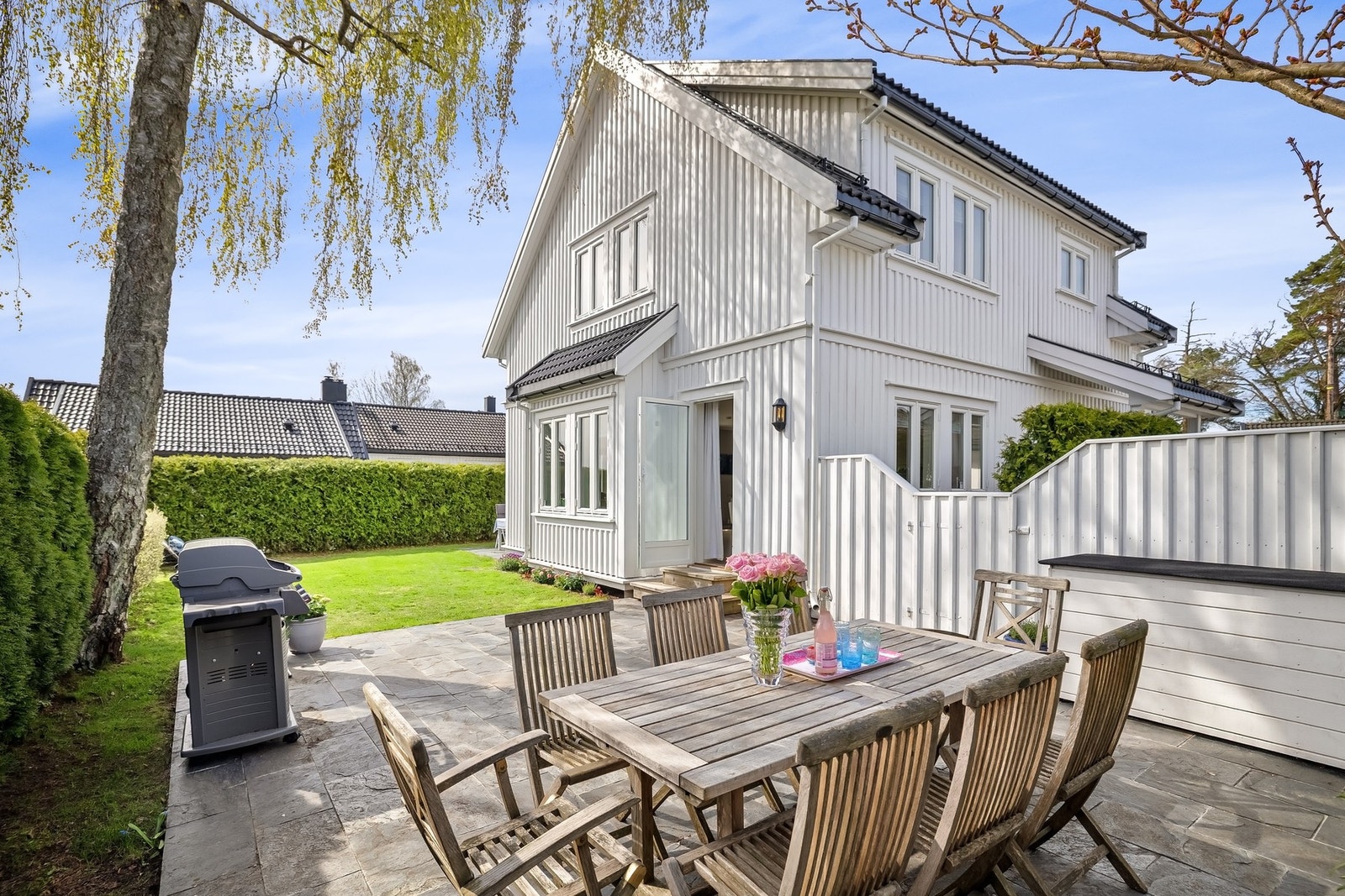 Utgang fra kjøkken avdeling, til stor og koselig terrasse platting med skiferflis, med både morgensol og kveldssol. Galleribilde
