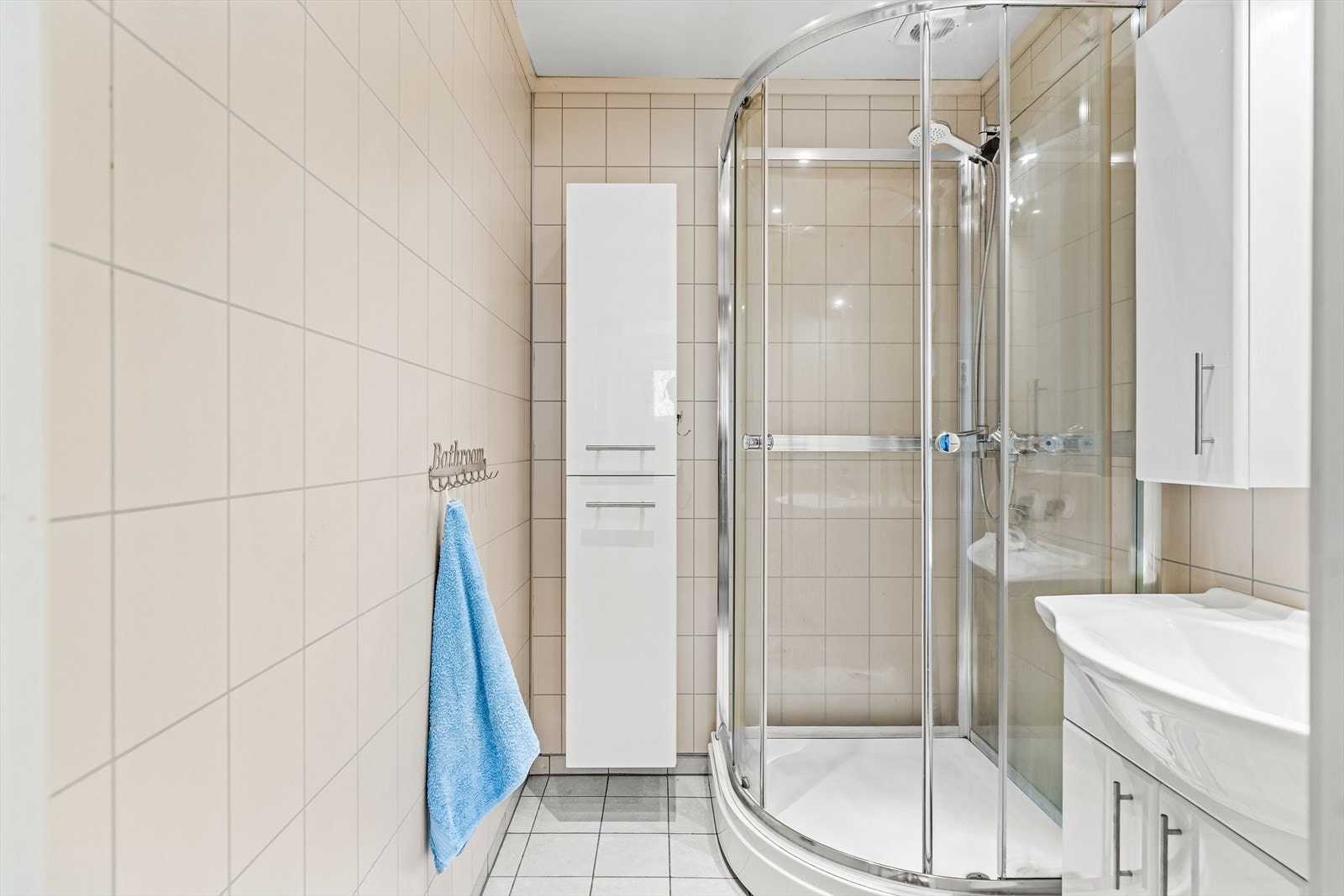 Badet ble pusset opp i 2012, innredet med hvite fliser på gulvet og beige våtromsplater i flismønster. Galleribilde