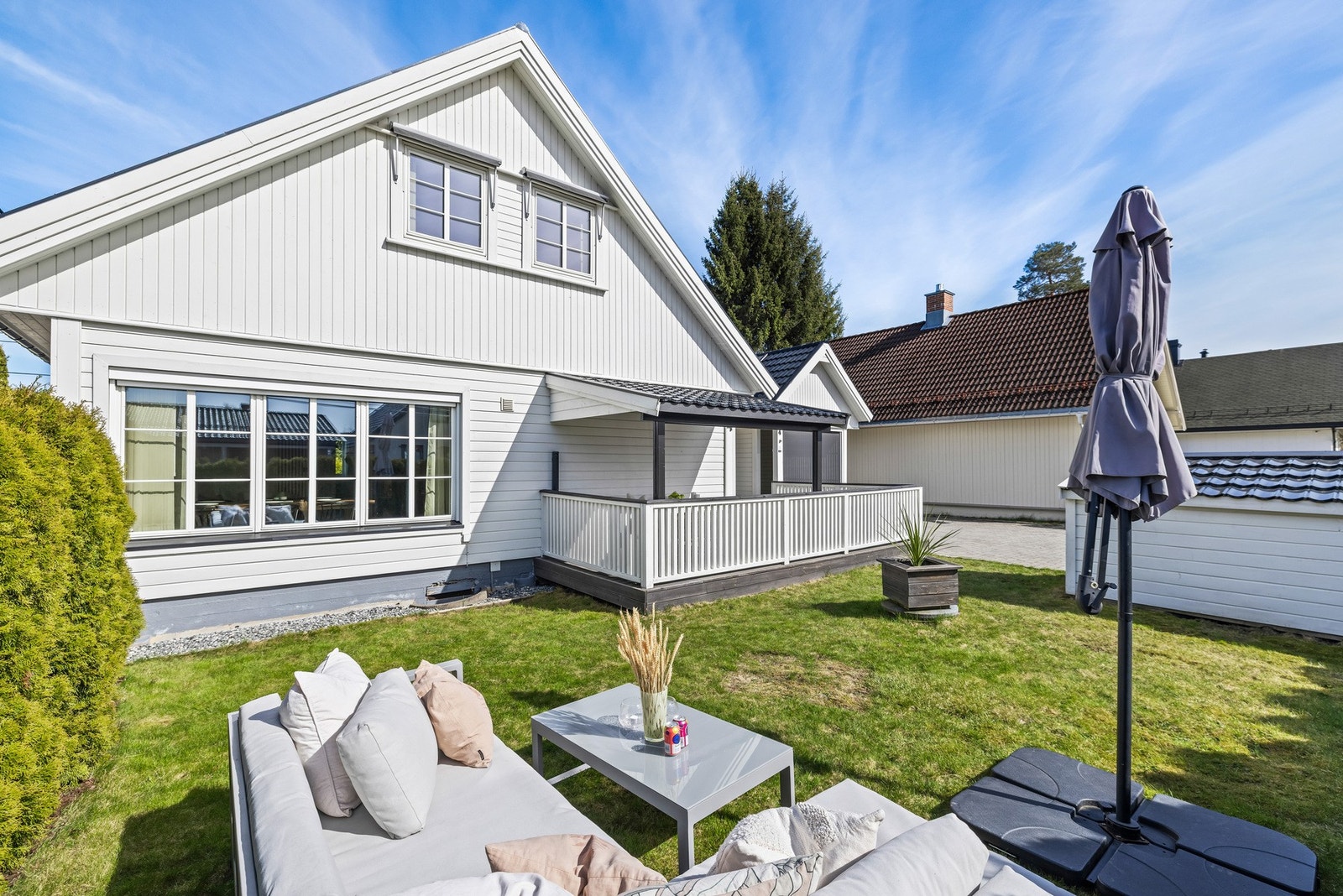 Foran terrassen ligger et pent opparbeidet hageareal med hekk, flatt plenareal og rikelig med plass til både trampoline og lek, ideelt for barnefamilier. Galleribilde