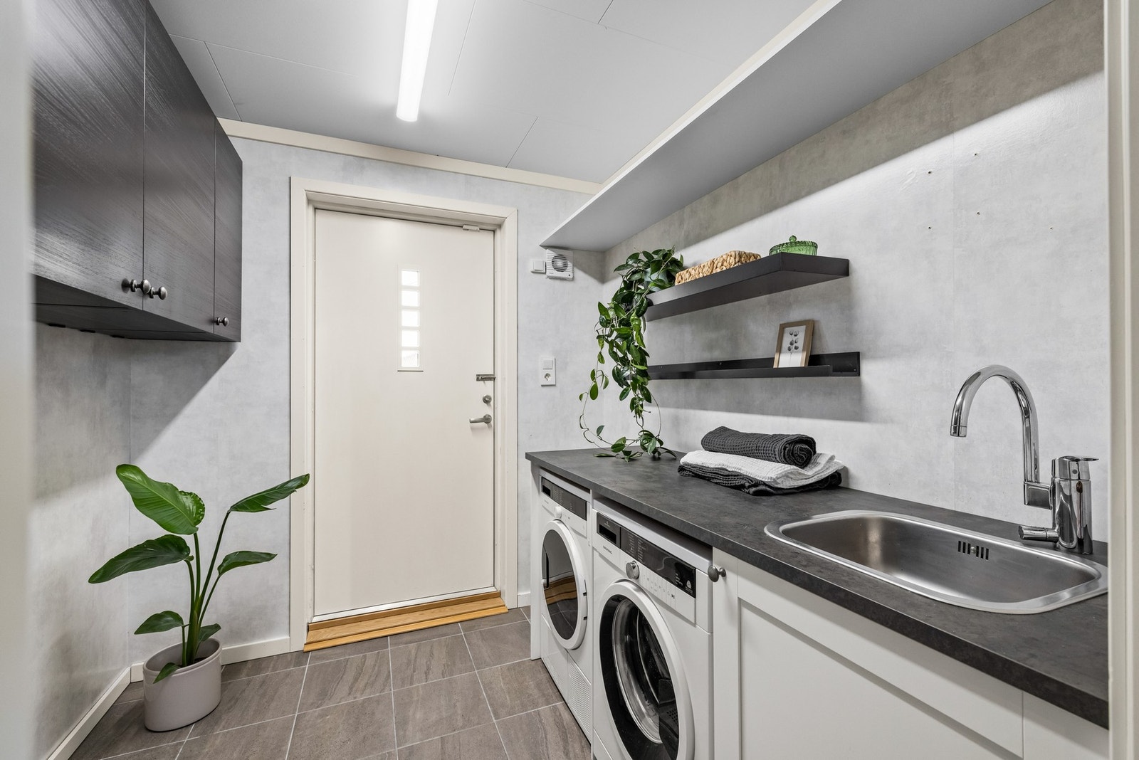 Rommet har egen utgang til hagen på baksiden som er perfekt når du kommer inn med våte klær, barn eller etter en litt gjørmete hundetur. Galleribilde