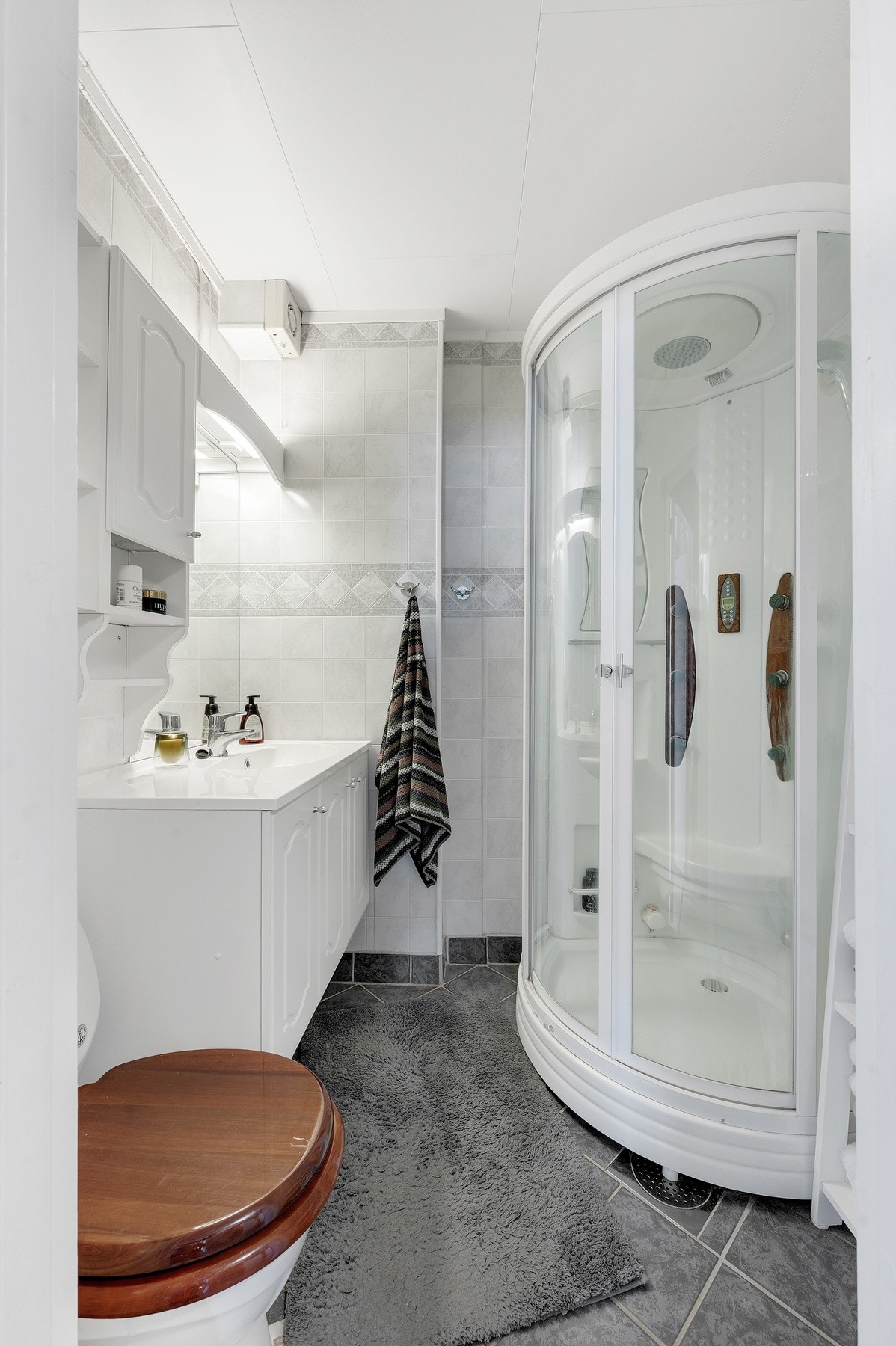 - Badet har flislagt gulv, romslig innredning og dusjkabinett. Galleribilde