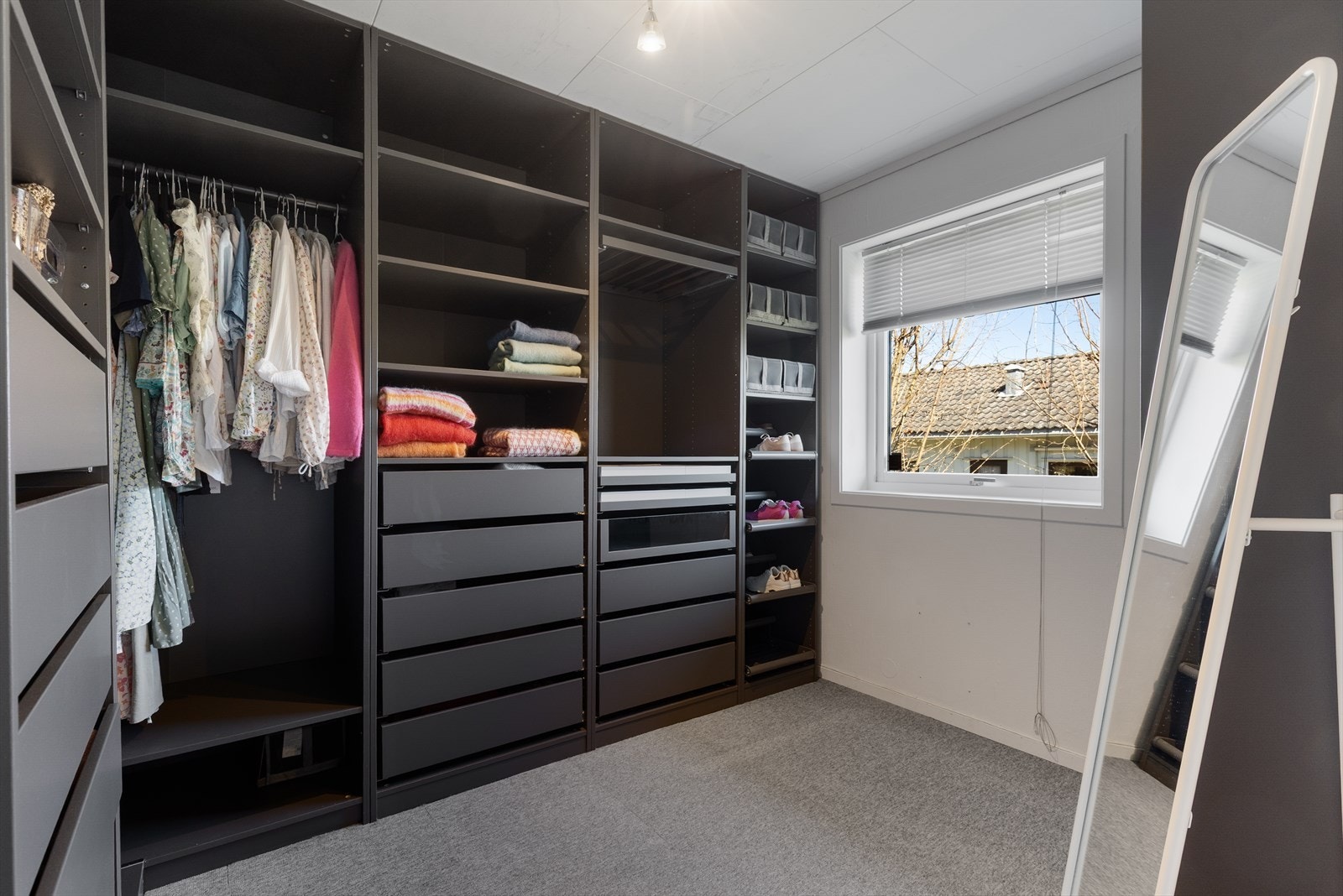 Et praktisk rom i kjelleren er innredet som en romslig walk-in-garderobe. Rommet har varmekabler i gulvet. Galleribilde