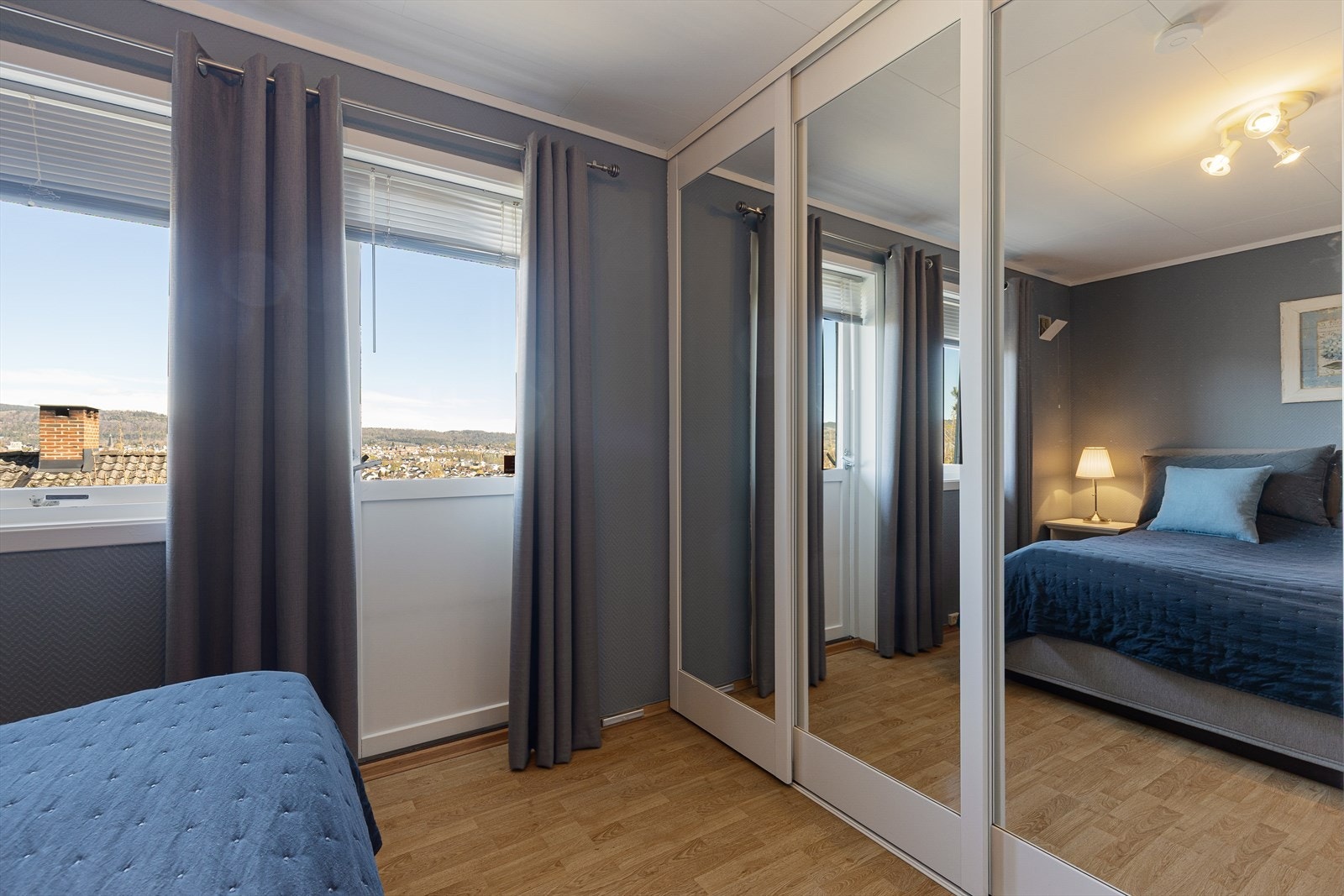 En stor skyvedørsgarderobe med speilfronter gir rikelig med oppbevaringsplass. Galleribilde