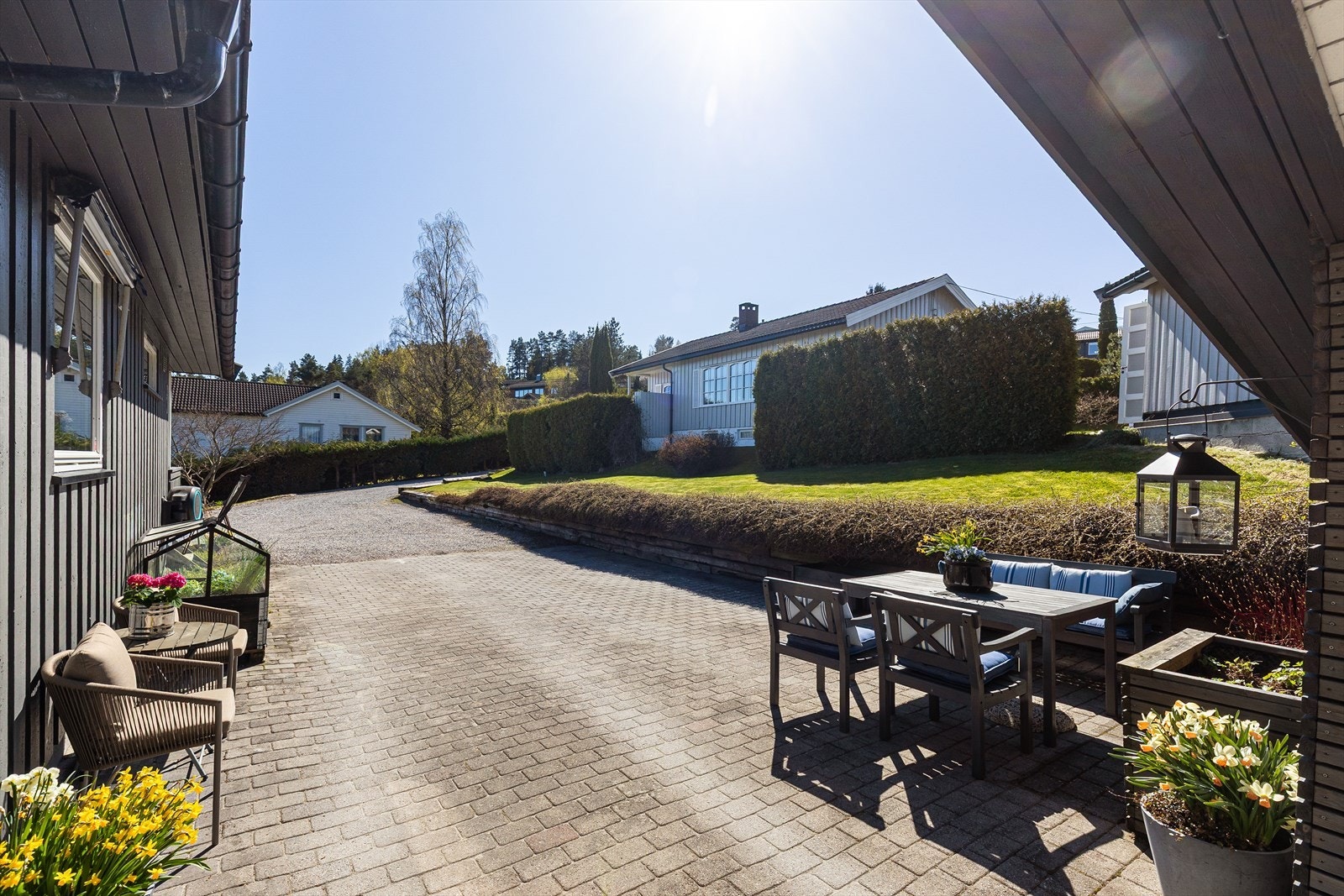 Uteplass ved inngangspartiet med belegningsstein og plass til en liten sittegruppe. Galleribilde