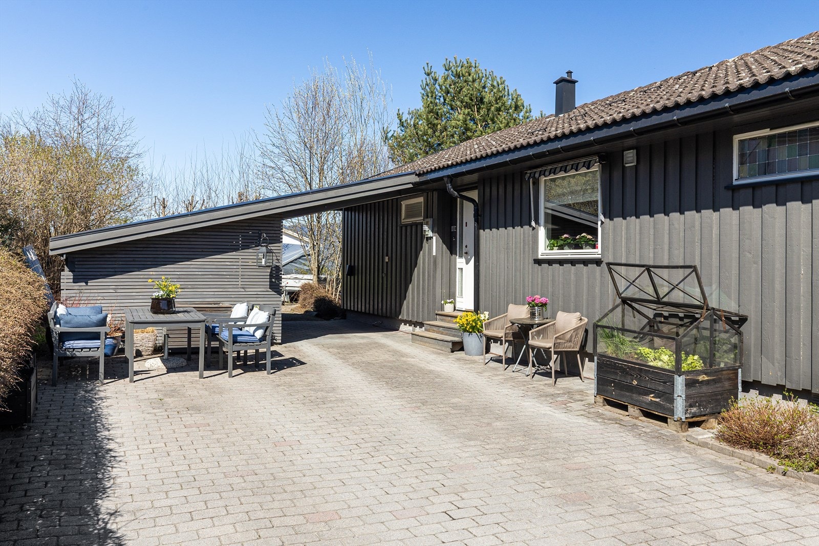 Carport med tilhørende vedbod. Det ble montert elbil-lader i 2023 - lune og solrike uteplasser Galleribilde
