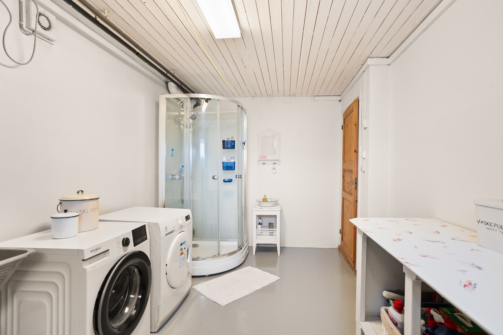 Praktisk vaskerom med elektrisk gulvvarme, dusjkabinett og opplegg for vaskemaskin og tørketrommel. Galleribilde