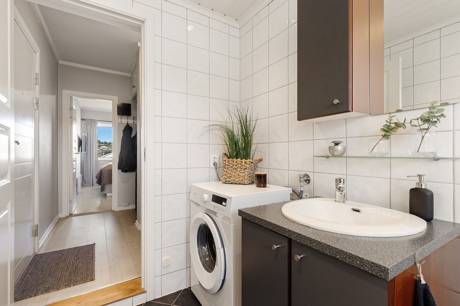 Badet er utstyrt med servant i innredning, toalett og badekar med dusjvegg. Galleribilde