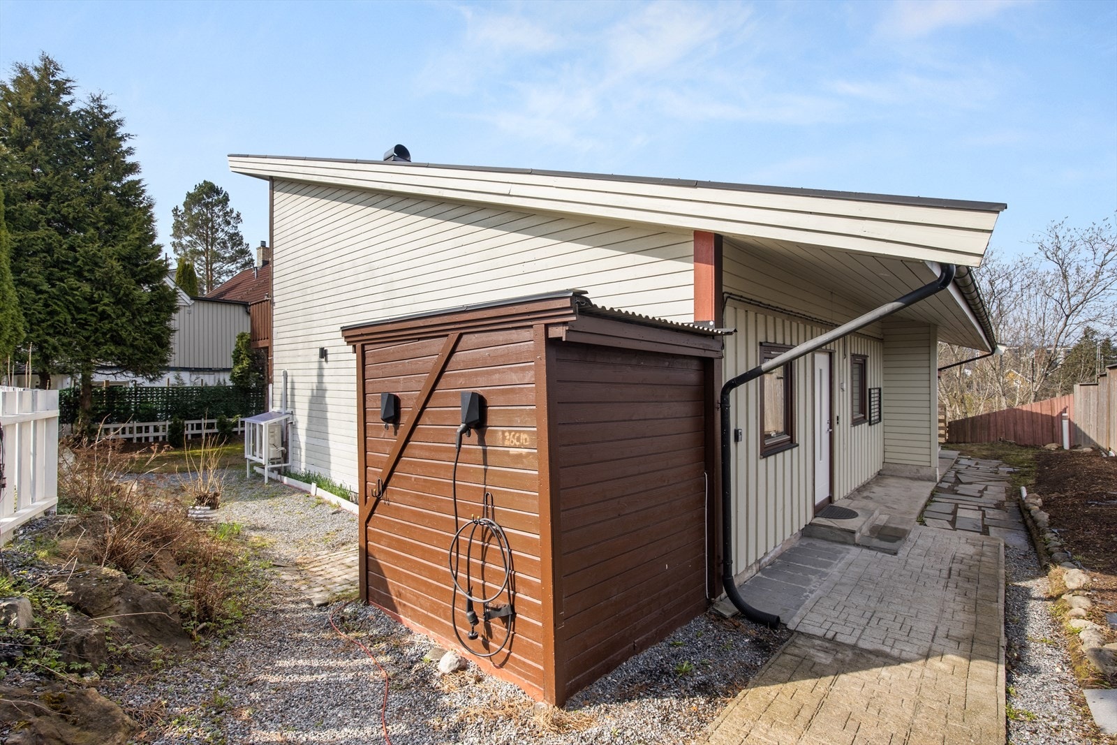 En frittstående bod i trekonstruksjon gir ekstra lagringsplass for hageredskaper og utstyr. Galleribilde