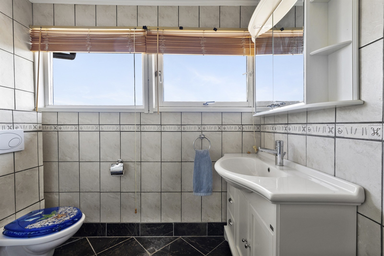 Badet er innredet med servant, veggmontert toalett og dusjkabinett. Galleribilde