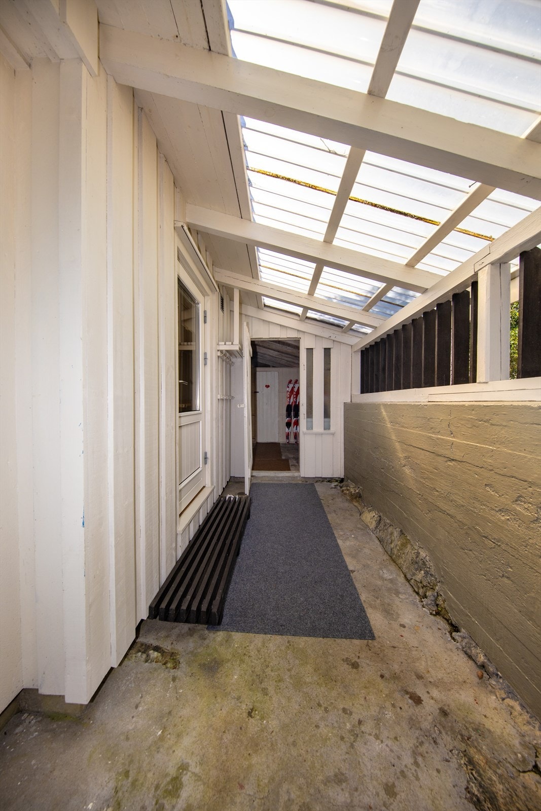 Overbygd inngangsparti, felles for hoveddel og tilleggsdel med bod og toalettrom. Galleribilde