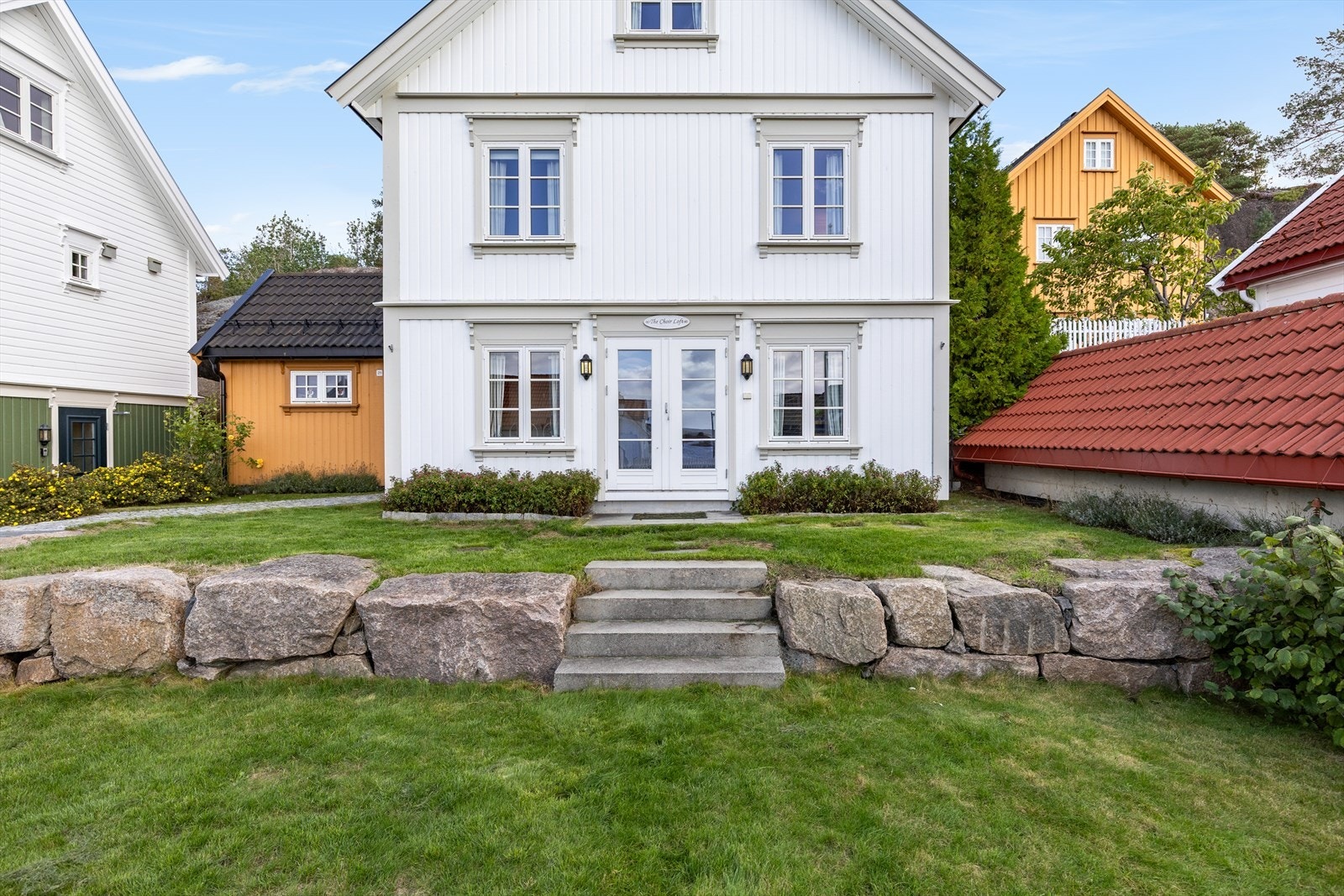 Hyggelig og opparbeidet uteområde med plen og mur Galleribilde