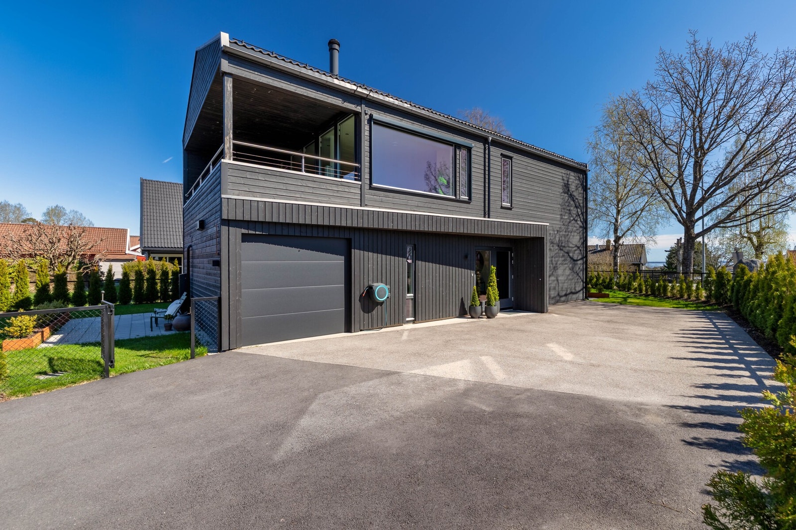 Romslig innkjørsel med god plass til parkering og tilhørende carport. Galleribilde