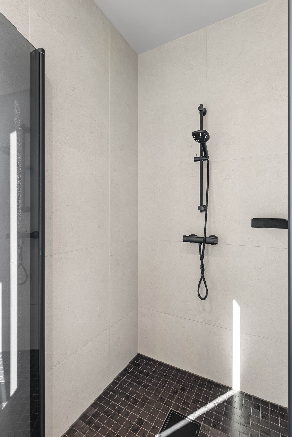 Innredet med servantinnredning, speil med lys, dusjvegg/dusjdør og wc. Galleribilde