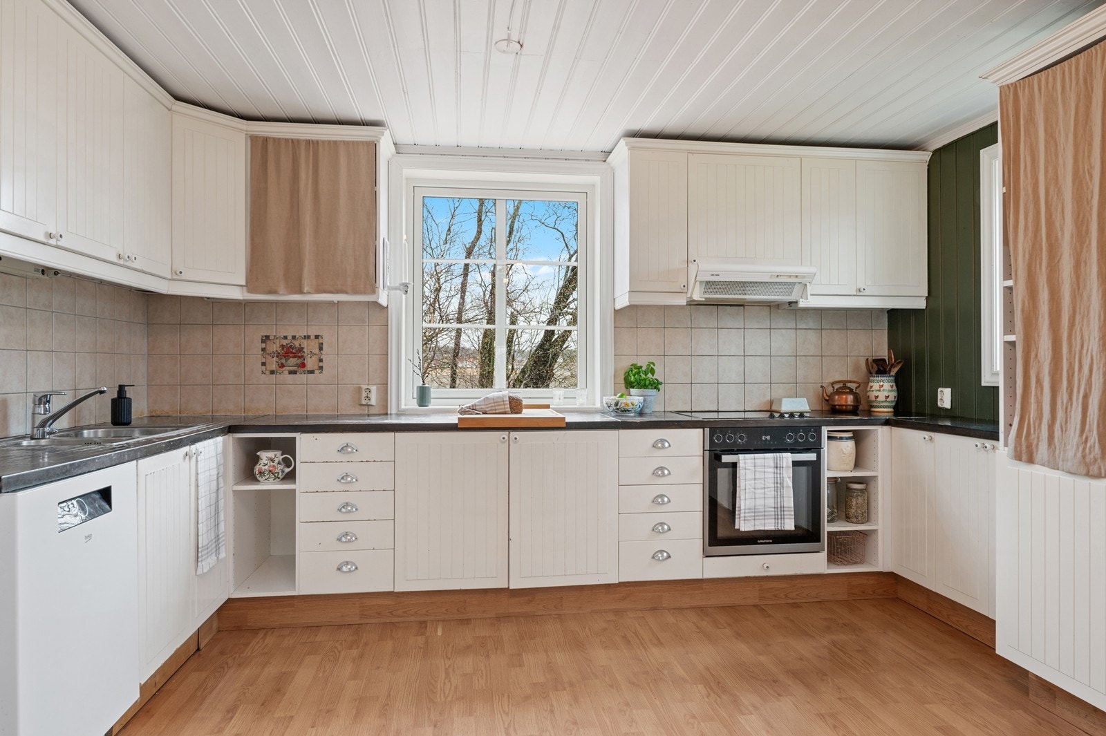 Kjøkkeninnredning fra rundt 2010 med profilerte fronter og en solid benkeplate i heltre. Galleribilde
