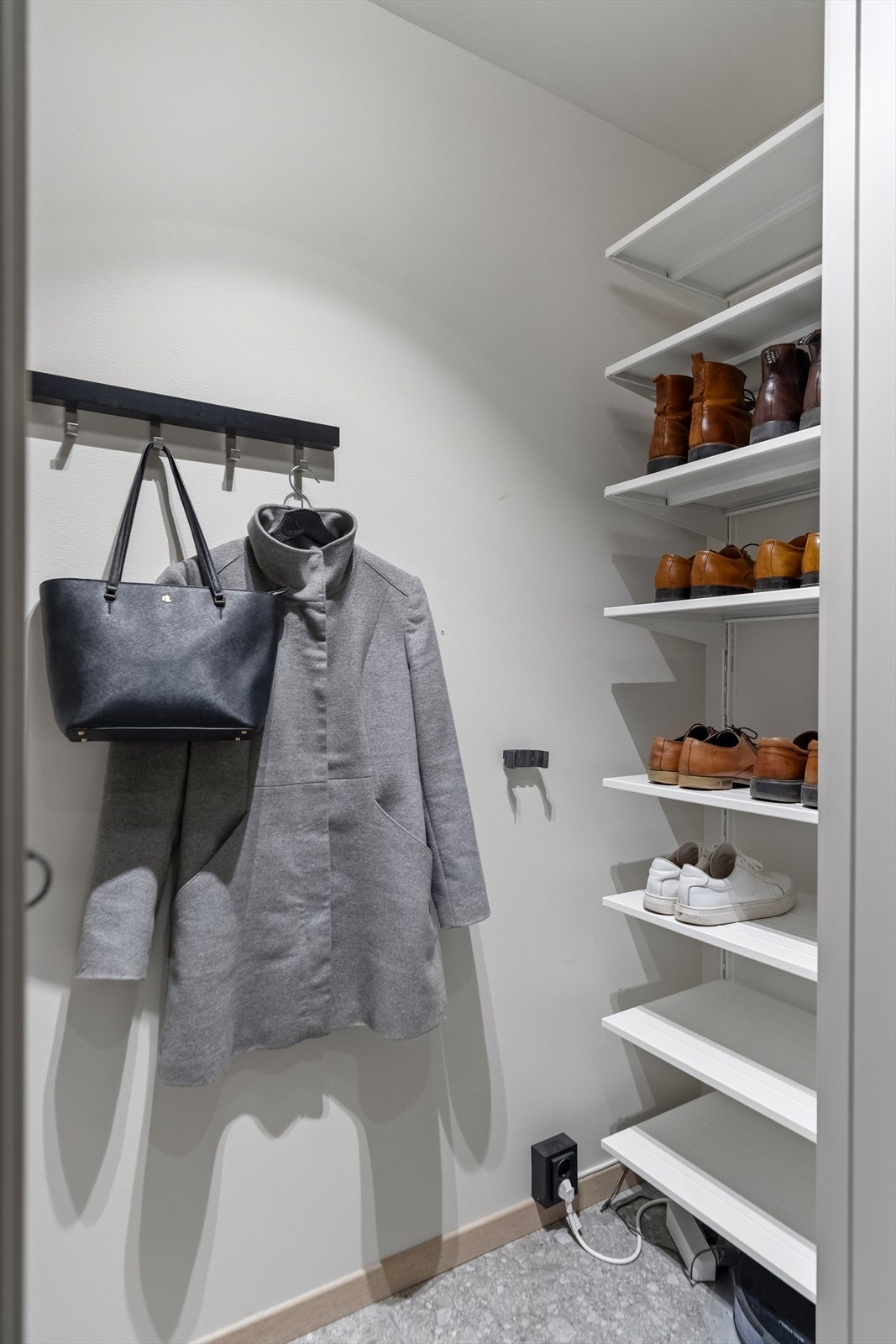 Yttertøyet ryddes enkelt bort i et stort garderobeskap med lysegrå skuffer og fronter. Ikke nok med det; tilknyttet entreen finner man et walk-in closet med hylleløsning. Galleribilde