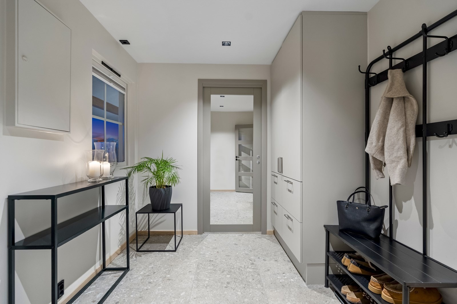 Entreen gir et flott førsteinntrykk med downlights, lysegrå vegger og store, grå gulvfliser i et lekkert, subtilt mønster. Galleribilde