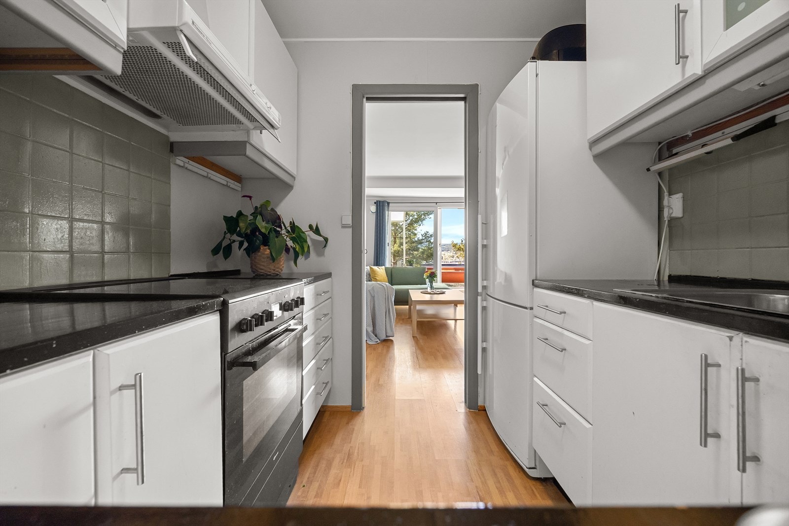 Kjøkkenet er funksjonelt utformet med gode arbeidsforhold, samt rikelig med skap- og benkeplass. Innredningen har slette fronter og gir et tidløst uttrykk. Benkeplater i malt heltre, kum i rustfritt stål og ett-greps blandebatteri. Galleribilde