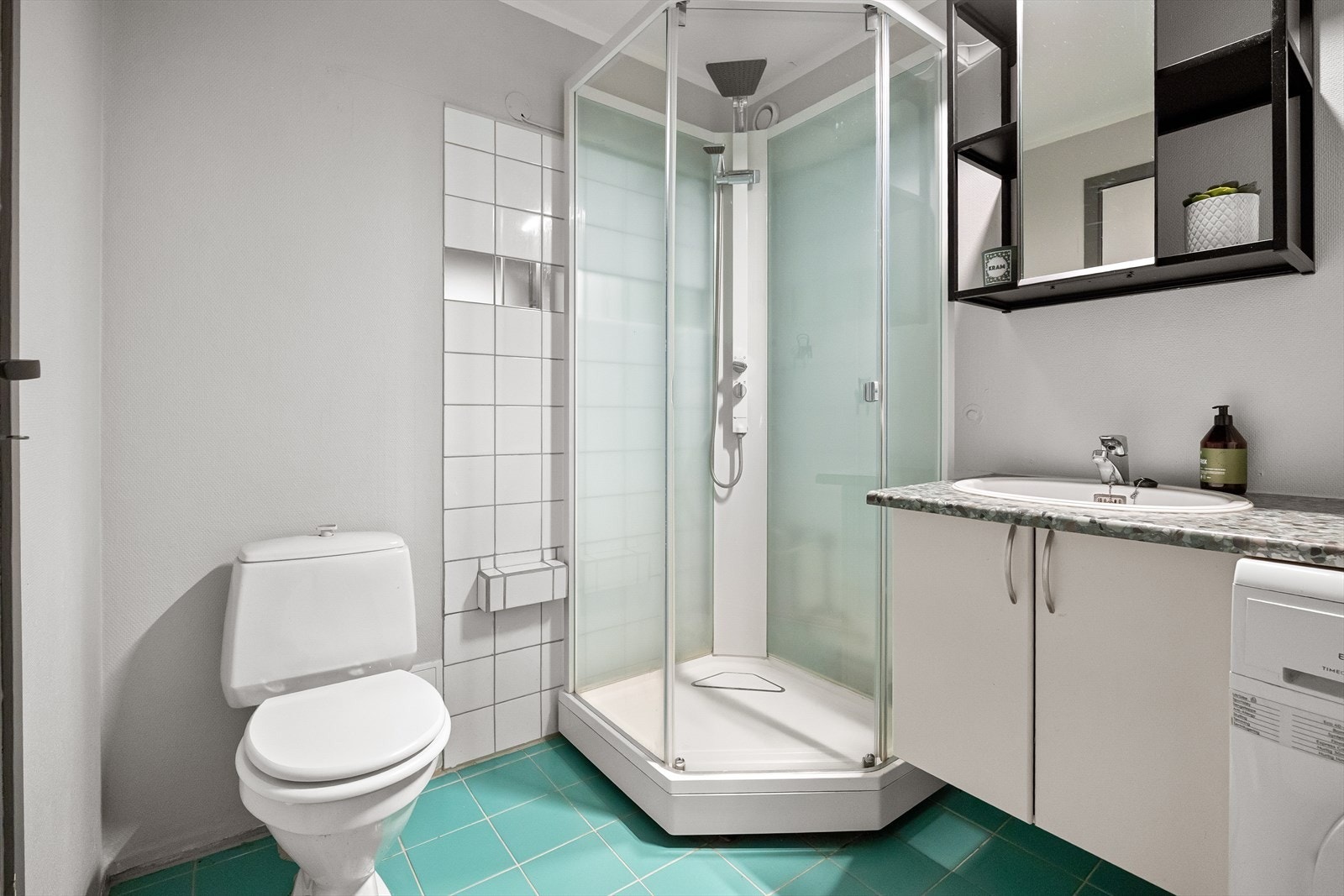 Badet er innredet med servantskap med laminat benkeplate, servant og ett-greps blandebatteri. Videre er det speilskap, gulvstående toalett og dusjkabinett. Det er også opplegg for vaskemaskin, som gir en praktisk og funksjonell løsning i hverdagen. Galleribilde